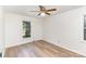 Bright bedroom features a ceiling fan, wood floors, and natural light from windows at 16320 Peach Grove Ln, Charlotte, NC 28277