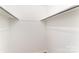 Walk-in closet with simple shelving and a clean, minimalist design at 16320 Peach Grove Ln, Charlotte, NC 28277