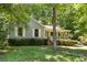 Charming single-story home with a cozy front porch surrounded by lush greenery and mature trees at 16320 Peach Grove Ln, Charlotte, NC 28277