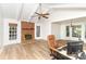 Bright living room featuring a brick fireplace, wood floors, vaulted ceiling, and a ceiling fan at 16320 Peach Grove Ln, Charlotte, NC 28277