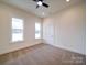Bedroom with neutral tones, carpet, ceiling fan, and two windows providing natural light at 1706 Ruben Rd, Monroe, NC 28112
