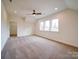 Bright bedroom featuring plush carpeting, ceiling fan, and natural light from three large windows at 1706 Ruben Rd, Monroe, NC 28112