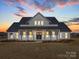 Stunning two-story home featuring a covered front porch and a manicured lawn at sunset at 1706 Ruben Rd, Monroe, NC 28112