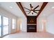 Open living room features a cozy fireplace, exposed beams and modern ceiling fan at 1706 Ruben Rd, Monroe, NC 28112