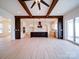 Bright, open-concept living room and kitchen with wood beam accents, modern lighting, and light wood flooring at 1706 Ruben Rd, Monroe, NC 28112