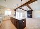 Open-concept kitchen and living room with a large island, modern fireplace, and stylish wood beam accents at 1706 Ruben Rd, Monroe, NC 28112