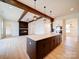 Open-concept living room and kitchen featuring a cozy fireplace, stylish wood beams, and a spacious island at 1706 Ruben Rd, Monroe, NC 28112