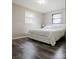 Bedroom featuring a bed with white linens, two windows, hardwood floors, and white walls at 18 Shannon Ct, Newton, NC 28658
