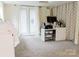 Carpeted bedroom features a sliding glass door and a desk with a chair and an assortment of items on top at 18 Shannon Ct, Newton, NC 28658