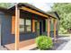 Inviting front porch with wood columns, dark siding, and manicured landscaping at 18 Shannon Ct, Newton, NC 28658