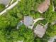 Aerial view of a secluded property featuring a pool, lush greenery, driveway, and multi-story home in a wooded setting at 1806 Asbury Hall Ct, Charlotte, NC 28209