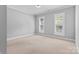 Bright bedroom with neutral walls, two windows, and plush carpet at 1806 Asbury Hall Ct, Charlotte, NC 28209