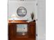 Hallway cabinet with glass shelving, a round mirror, and decorative items at 1806 Asbury Hall Ct, Charlotte, NC 28209