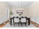 Dining room with modern chandelier, plantation shutters, and hardwood floors at 1806 Asbury Hall Ct, Charlotte, NC 28209