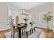 Dining room with modern chandelier, plantation shutters, and hardwood floors at 1806 Asbury Hall Ct, Charlotte, NC 28209