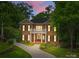 Elegant two-story brick home featuring white columns, balcony, dark shutters and a beautifully landscaped front yard at 1806 Asbury Hall Ct, Charlotte, NC 28209