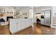 Open-concept kitchen with an island, desk area, stainless steel refrigerator and hardwood floors at 1806 Asbury Hall Ct, Charlotte, NC 28209