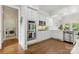Well-lit kitchen boasts stainless steel appliances, white cabinetry, and hardwood flooring at 1806 Asbury Hall Ct, Charlotte, NC 28209