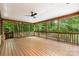 Spacious screened porch with wood floors, ceiling fan, and wooded views, perfect for outdoor relaxation and entertaining at 1806 Asbury Hall Ct, Charlotte, NC 28209