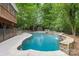 Luxury backyard showcasing a custom swimming pool with a stone waterfall feature and lush greenery, perfect for summer fun at 1806 Asbury Hall Ct, Charlotte, NC 28209