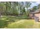 Green backyard featuring fence line, brick house, and air conditioning unit at 205 Timberfield Trl, China Grove, NC 28023