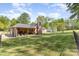 Large fenced backyard featuring brick home, fire pit, and green grass at 205 Timberfield Trl, China Grove, NC 28023