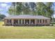 Charming single-story brick home featuring arched entryway, manicured lawn and mature trees at 205 Timberfield Trl, China Grove, NC 28023