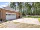 Side-entry garage with large concrete driveway and views of fenced backyard at 205 Timberfield Trl, China Grove, NC 28023