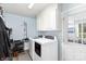 Efficient laundry room with white cabinets, a washer and dryer at 205 Timberfield Trl, China Grove, NC 28023
