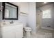 Bathroom featuring a white vanity, toilet and shower over tub with white tiles at 209 Woodstream Cir, Mooresville, NC 28117