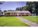 Charming brick home with manicured lawn, decorative shutters, complemented by a stone pathway leading to the front door at 209 Woodstream Cir, Mooresville, NC 28117
