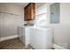 Laundry area with washer, dryer, freezer, cabinet, tile floors, and natural light at 209 Woodstream Cir, Mooresville, NC 28117