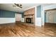 Cozy living room with brick fireplace, hardwood floors, a ceiling fan, and fresh paint at 209 Woodstream Cir, Mooresville, NC 28117