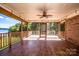 View of a covered porch with a ceiling fan and wooden railings overlooking the lake at 209 Woodstream Cir, Mooresville, NC 28117