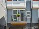 Cozy balcony with gray siding, black railing, and chair with a potted plant for relaxing outdoors at 2111 Isom St, Charlotte, NC 28208