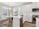 A bright kitchen featuring white cabinets, quartz countertops, stainless steel appliances, and a dining table at 2111 Isom St, Charlotte, NC 28208