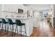 An open kitchen features white cabinets, stainless steel appliances, and hardwood floors that flow into the living area at 2111 Isom St, Charlotte, NC 28208