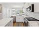 An all-white kitchen with stainless steel appliances, quartz countertops, and a breakfast area with light-filled windows at 2111 Isom St, Charlotte, NC 28208
