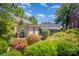Backyard view with a deck, sunroom, and lush landscaping under a blue sky at 2125 Chatham Ave, Charlotte, NC 28205