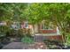 A classic brick home features a cozy front porch with iron railings and manicured landscaping at 2125 Chatham Ave, Charlotte, NC 28205