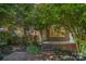 A charming brick home features a cozy front porch with iron railings and beautiful landscaping at 2125 Chatham Ave, Charlotte, NC 28205