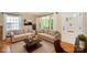 Bright living room featuring two sofas, a neutral rug, hardwood floors, and a sunny window with white trim at 2125 Chatham Ave, Charlotte, NC 28205