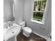 Bathroom features a pedestal sink, toilet, and a window providing natural light at 2140 Majestic Poplar Dr, Waxhaw, NC 28173