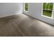 Spacious carpeted bedroom with two windows showcasing the lush outdoor greenery at 2140 Majestic Poplar Dr, Waxhaw, NC 28173