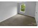 Bright bedroom featuring neutral carpet, white walls, and natural light from a window at 2140 Majestic Poplar Dr, Waxhaw, NC 28173