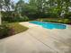 Backyard pool with a concrete surround and lush green landscaping at 2140 Majestic Poplar Dr, Waxhaw, NC 28173