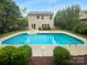Refreshing in-ground pool surrounded by a spacious patio, lush landscaping, and privacy fence at 2140 Majestic Poplar Dr, Waxhaw, NC 28173