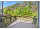 Spacious outdoor deck with a wooden green border offers a serene view of mature trees at 218 Water Oak Dr, Pineville, NC 28134