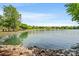 Picturesque lake view with rocky shores, lush greenery, and clear skies create a tranquil setting at 218 Water Oak Dr, Pineville, NC 28134