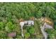 Aerial view of the home showcasing wooded lot, long driveway, and nearby homes at 2202 Bearskin Ln, Monroe, NC 28110